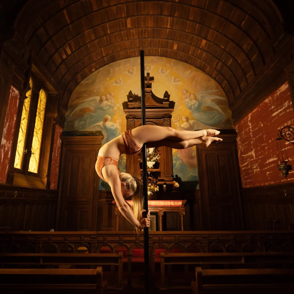 Madame Passions réalisant une figure de pole dance